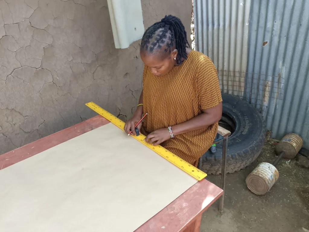 a woman sizing and cutting khaki paper